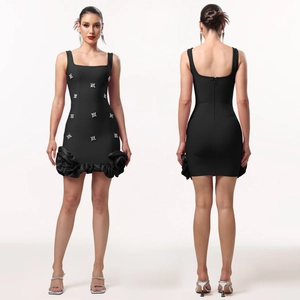 Détails d'une robe noire ajustée avec strass argentés et ourlet floral en relief chic