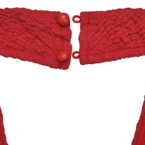 Dettaglio dello scollo dell'abito rosso con tessuto goffrato a bolle e chiusura con bottoni