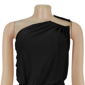 Detail of black one-shoulder jumpsuit with elegant pleats and golden metal ring detail