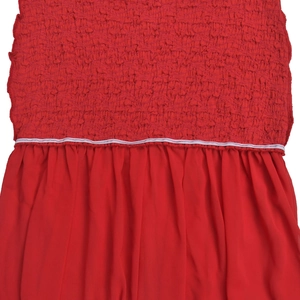 Dettaglio vestito rosso con corpetto a punto smock elastico e tessuto in chiffon arricciato