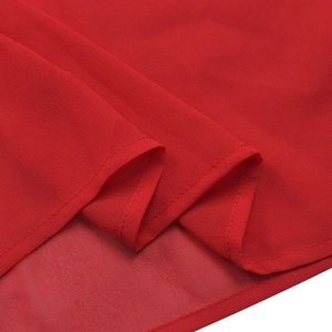 Dettaglio dell'orlo di un abito in chiffon rosso con cucitura precisa a bordo arrotolato