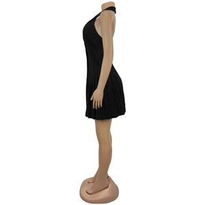 Side view of black backless halter dress showing pleated skirt details on a mannequin
