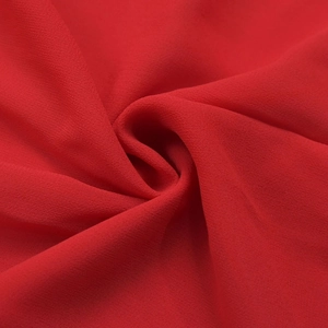 Dettaglio macro del tessuto in chiffon rosso con texture premium e drappeggio elegante