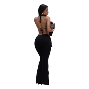 Detail of a black backless halter crop top and high-waisted flared trousers set