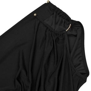 Close-up of black pleated fabric featuring gold metal ring and rivet details