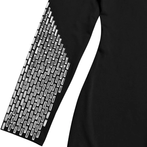 Détail de la manche d'une robe noire ornée de rangées verticales de strass brillants