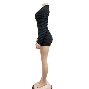 Close-up of black long sleeve romper featuring textured popcorn fabric and zipper detail