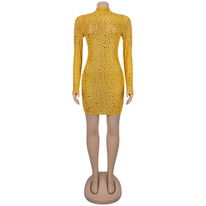 Dettaglio del mini abito giallo in rete con decorazioni di strass ambra scintillanti