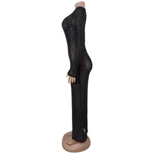 Dettaglio del vestito in rete nera trasparente con strass e maniche lunghe