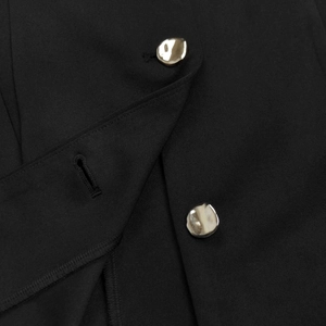 Detailed macro view of black fabric texture with unique irregular silver metal buttons