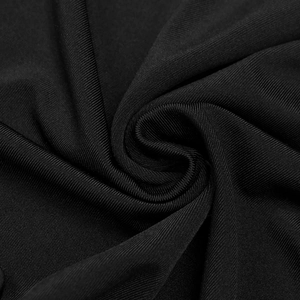 Macro shot of black ribbed knit fabric showing fine texture and soft draped material