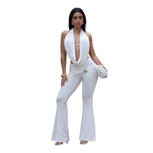 Detail of white two-piece set featuring halter neck top and high-waisted flared pants