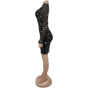 Dettaglio mini abito in rete nera con strass scintillanti e maniche lunghe eleganti