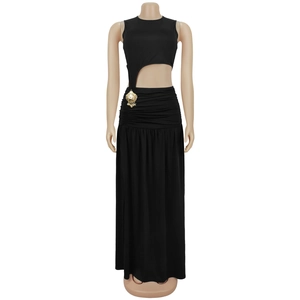 Detail of black sleeveless dress with side waist cutout and gold shell pendant decor