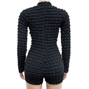 Detail of black long sleeve romper featuring 3D bubble waffle texture and high neck design