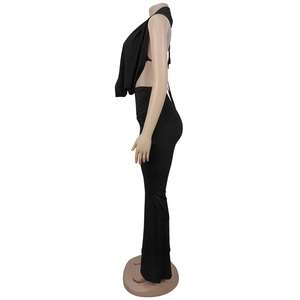 Side view detail of black halter backless crop top and high waisted flare pants set
