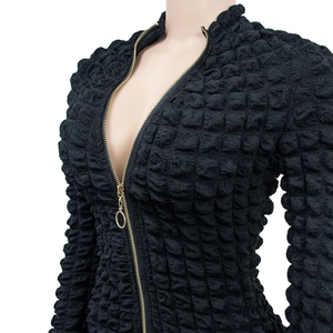 Detail of black popcorn texture fabric and gold metal zipper with round puller