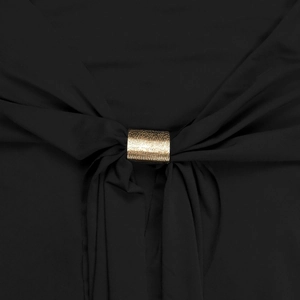 Dettaglio di un elegante abito nero con anello in metallo dorato e drappeggio