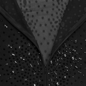Dettaglio di abito in mesh nero con ricami di perline e cerniera a goccia raffinata