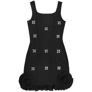 Détail d'une robe noire moulante avec roses 3D et fleurs étincelantes en strass brillants