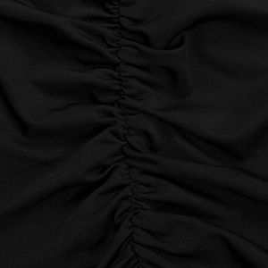 Detailed macro shot of black elastic ribbed fabric with elegant ruching texture on dress