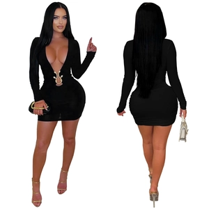 Détail du décolleté en V profond avec boucles de serpent dorées sur une mini robe noire