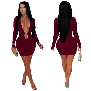 Détail de robe bordeaux avec décolleté plongeant et boucle serpent dorée