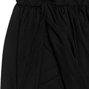 Detail shot of the side slit and gathered waist pleats on a black sleeveless dress