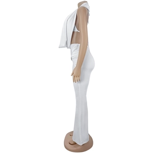 Side view of white backless crop top and high waisted flare pants set on a model