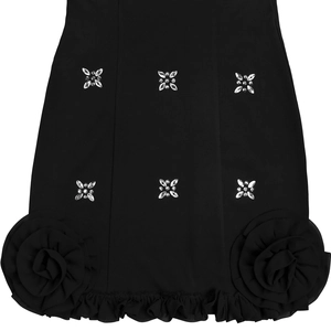 Détail d'une robe noire avec des motifs d'étoiles en strass et des roses en mousseline 3D