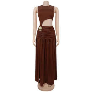 Detail of side cutout on brown sleeveless maxi dress with gold shell accent