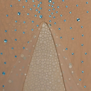 Détail du tissu en maille chair avec strass bleu clair et texture transparente