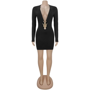 Détail d'une robe noire à décolleté en V profond avec boucle métallique dorée en forme de serpent