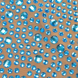 Gros plan de strass bleu clair étincelants sur tissu mesh pour une robe moulante