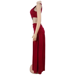 Detail view of the deep red two-piece set featuring high-waisted pleated maxi skirt texture