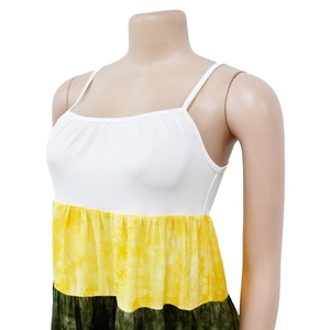 Dettaglio abito bohémien a balze con corpetto bianco e gonna tie-dye giallo-verde