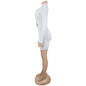 Détail de la robe courte blanche à manches longues avec anneau doré à la taille