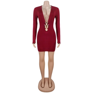Vue détaillée du décolleté en V profond avec boucle serpent dorée sur la robe bordeaux chic
