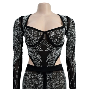 Close-up of sheer mesh jumpsuit with silver rhinestones and waist cut-out details