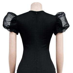 Dettaglio dell'abito nero con scollo a V e maniche a sbuffo in mesh trasparente elegante