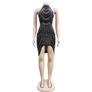 Detail of black halter party dress with shimmering silver rhinestones and fringe hemline