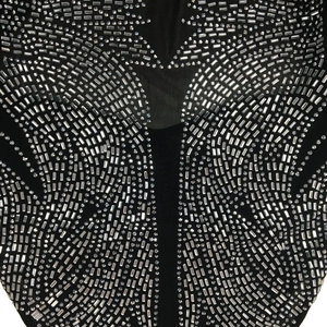 Detail of silver rhinestones and sheer mesh fabric on black long-sleeve jumpsuit
