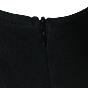 Dettaglio della cerniera invisibile a goccia su questo abito nero con scollo a V e sbuffo