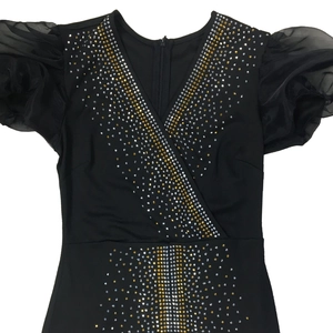 Dettaglio dello scollo a V con strass scintillanti e eleganti maniche a sbuffo