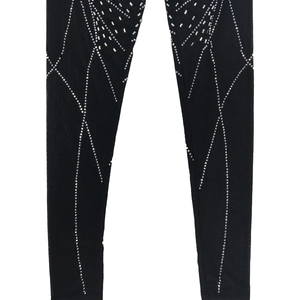 Detail of black mesh jumpsuit featuring silver rhinestone spiderweb patterns
