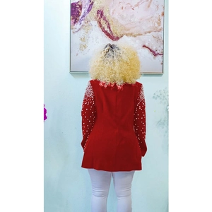 Detail showing red blazer sleeves with white pearl beads and elegant back tailoring