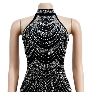 Detailed close-up of a black halter neck dress featuring intricate silver rhinestone patterns