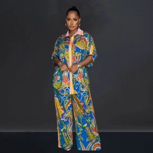 Detail of vibrant paisley floral print fabric on silky bohemian shirt and wide-leg pants