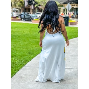 Back view of a white halter maxi dress with artistic blue and yellow prints on knit fabric