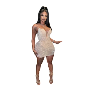 Détails des strass scintillants et du col en V en mesh transparent sur une robe moulante